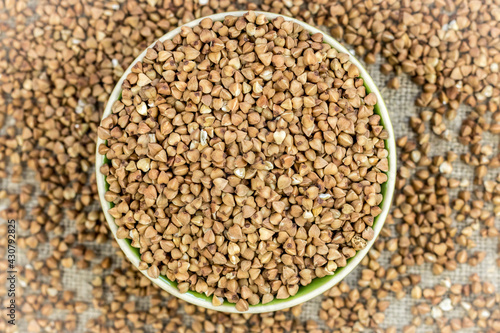 buckwheat (raw, dry) is poured into a round plate, defocused buckwheat is scattered around