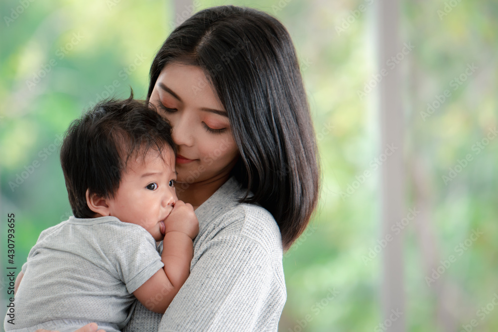 Young beautiful asian mother lifting and playing with her baby. Young beautiful asian mother lifting and playing with her baby.