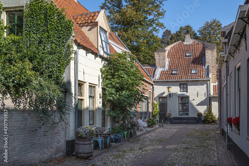 Fototapeta Naklejka Na Ścianę i Meble -  Small street with old small and authentic houses and flowers in the center of Elburg in the Netherlands.	