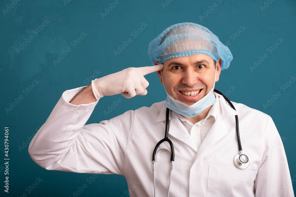 a distraught doctor, a stethoscope on his shoulders, twirls his finger at his temple a distraught doctor, a stethoscope on his shoulders, twirls his finger at his temple