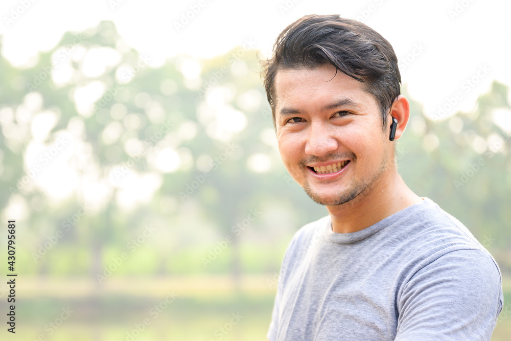 Close-up focus in front of a handsome Asian man who is sweaty for morning exercise. The young Asian man smiled and looked at the camera. Close-up focus in front of a handsome Asian man who is sweaty for morning exercise. The young Asian man smiled and looked at the camera.