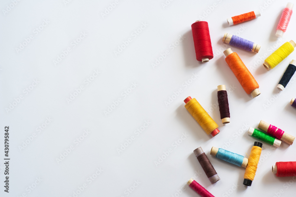 Frame with multi-colored reels with threads on a white background. Top View Frame with multi-colored reels with threads on a white background. Top View