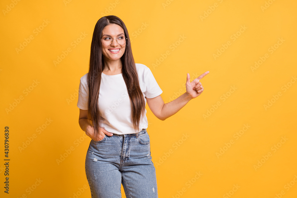 Photo of pretty nice brown haired woman point finger empty space advertise isolated on shine yellow color background Photo of pretty nice brown haired woman point finger empty space advertise isolated on shine yellow color background