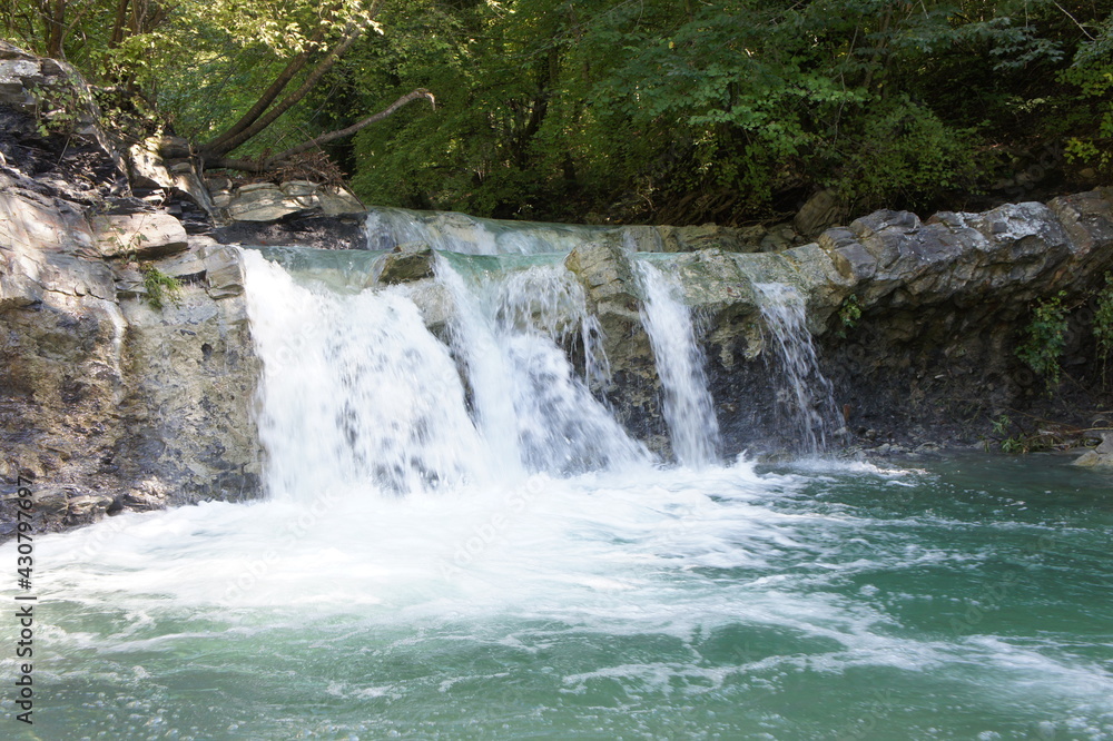 Rapid water flow and waterfall in the bed of the Zhane River in the North Caucasus Rapid water flow and waterfall in the bed of the Zhane River in the North Caucasus
