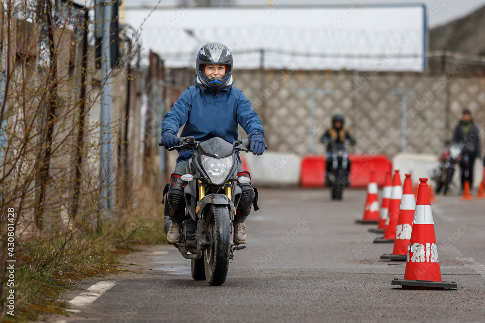 motorcycle driving school. a woman learns to drive before obtaining a driving license. motorcycle driving school. a woman learns to drive before obtaining a driving license.