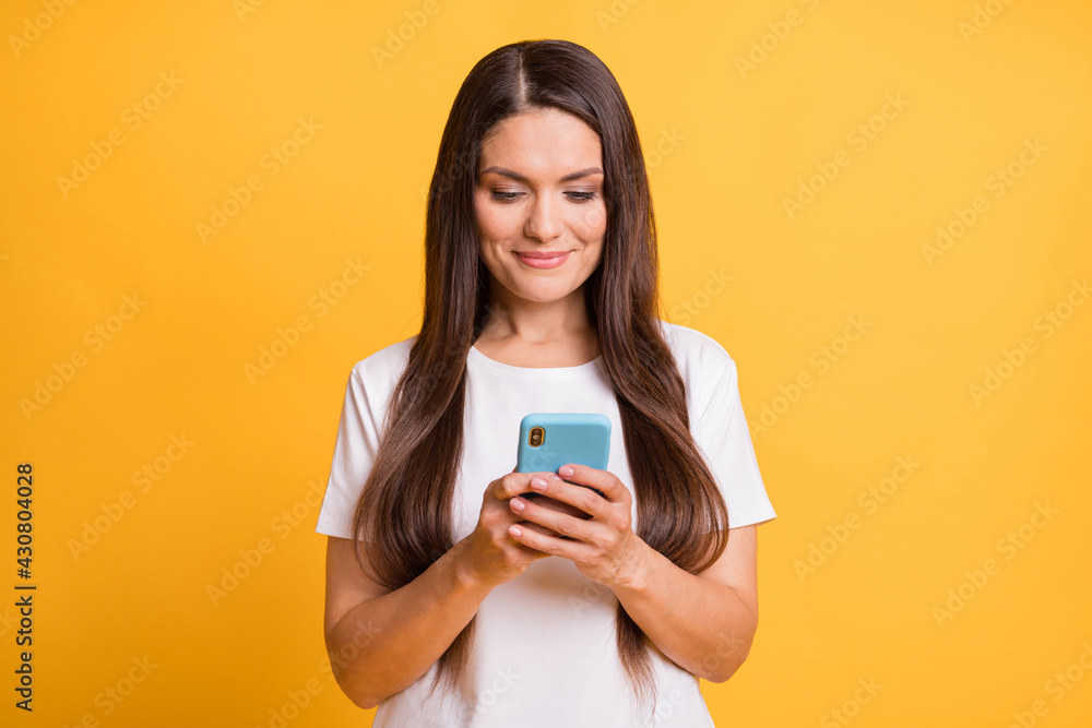 Photo portrait of blogger typing message on cellphone smiling in casual clothes isolated on vivid yellow color background Photo portrait of blogger typing message on cellphone smiling in casual clothes isolated on vivid yellow color background