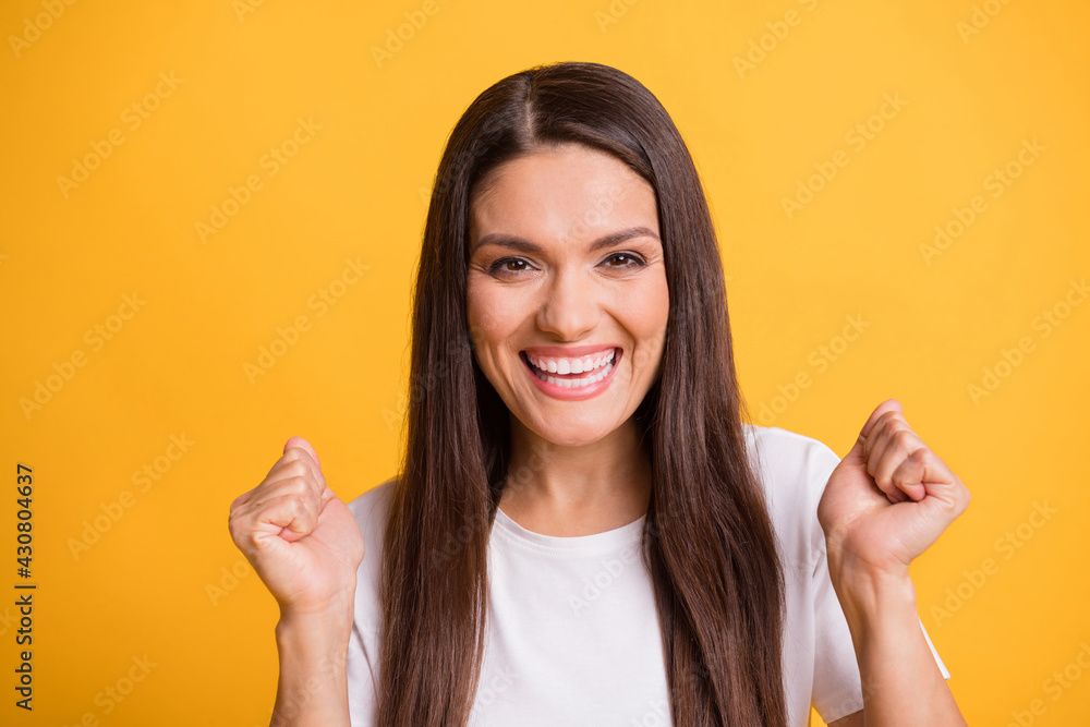 Photo portrait of happy cheerful woman laughing gesturing like winner isolated on bright yellow color background Photo portrait of happy cheerful woman laughing gesturing like winner isolated on bright yellow color background