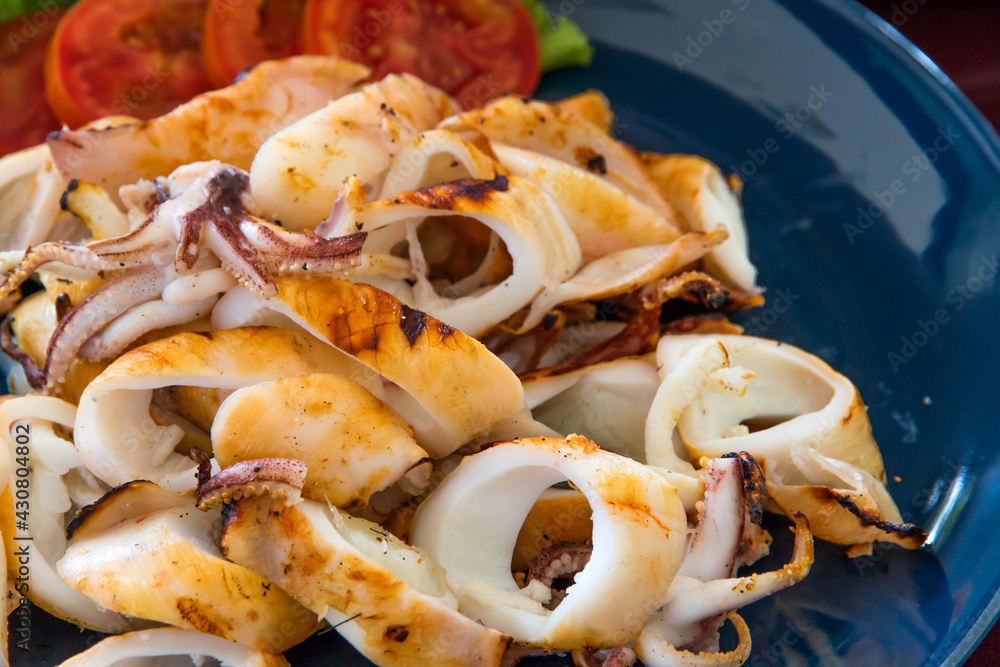 Grilled squid and vegetable on plate,Grilled squid on dish wooden table Grilled squid and vegetable on plate,Grilled squid on dish wooden table