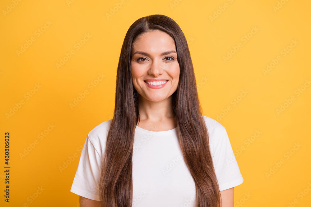 Fototapeta premium Photo portrait of brunette woman smiling wearing white t-shirt isolated on bright yellow color background