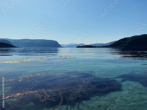 view of the sea from the mountain, fjord, transparent water, horizon over the sea, blue sky, nordic landscape