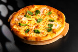 Pizza is not a wooden board. Black background. close-up.
