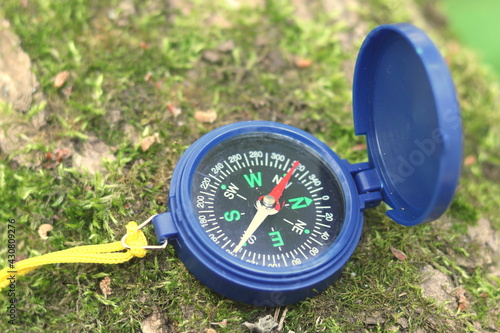 Classic navigation compass on natural background as symbol of tourism with compass, travel with compass and outdoor activities with compass