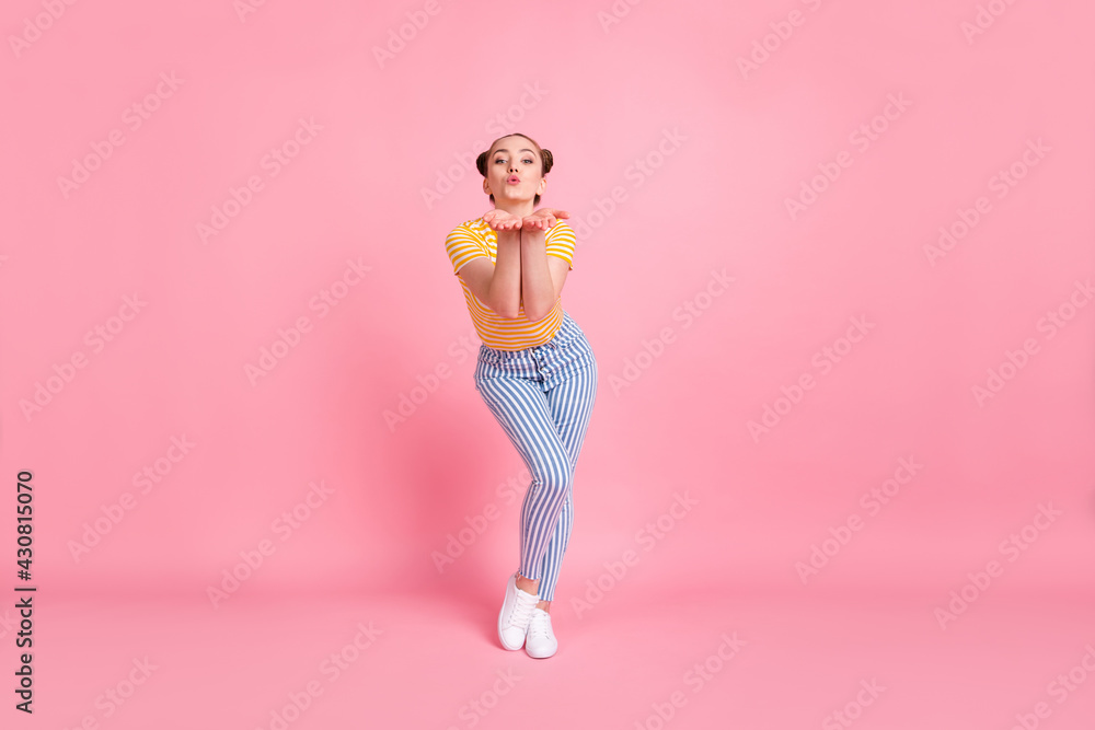 Full size photo of optimistic nice brunette lady stand blow kiss wear yellow t-shirt pants sneakers isolated on pink color background Full size photo of optimistic nice brunette lady stand blow kiss wear yellow t-shirt pants sneakers isolated on pink color background
