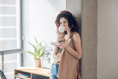 Young smiling woman having coffee in the morning