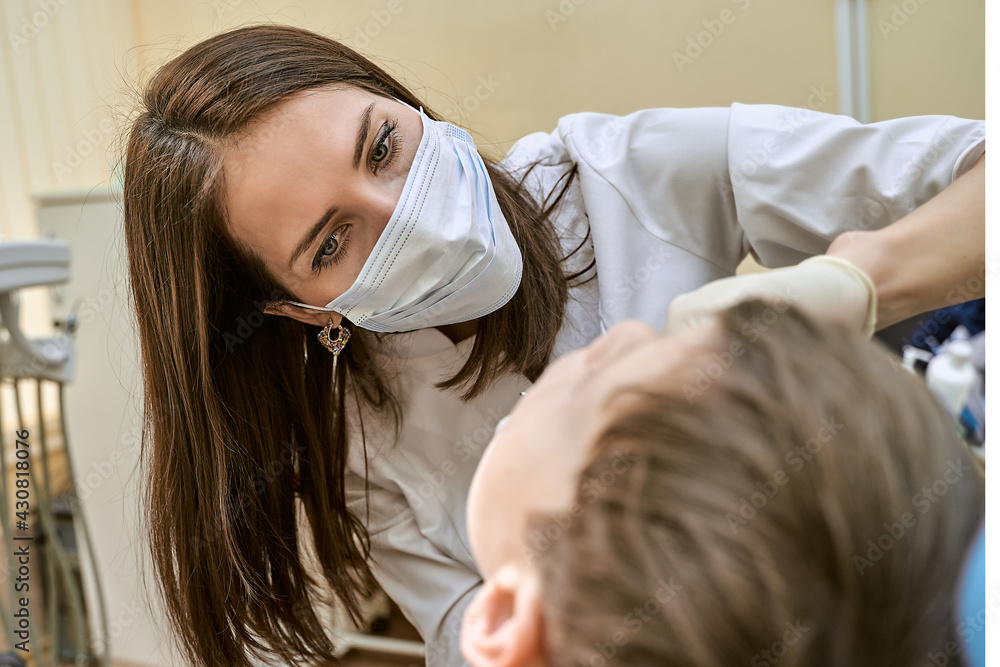 Fototapeta premium an orthodontist at his workplace examines the patient's oral cavity