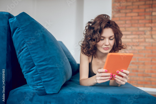Принти на полотні Pretty woman watching something online and looking interested