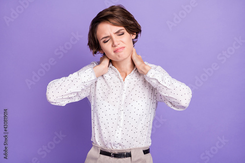 Portrait of unsatisfied lady closed eyes hands on neck suffering bad mood isolated on purple color background