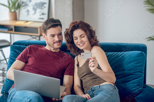 Young couple choosing something for buying online