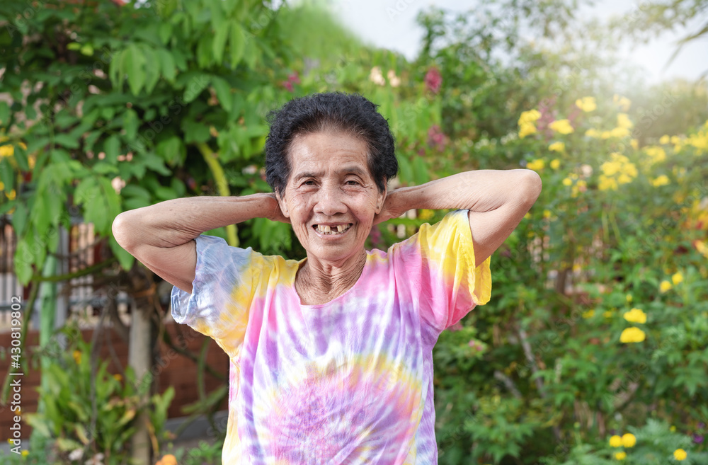 Old Asian woman face with wrinkle elderly senior smiling happiness with a few broken teeth. Happy aged person exercising at sunrise with missing tooth has positive thoughts on life. Healthcare concept Old Asian woman face with wrinkle elderly senior smiling happiness with a few broken teeth. Happy aged person exercising at sunrise with missing tooth has positive thoughts on life. Healthcare concept