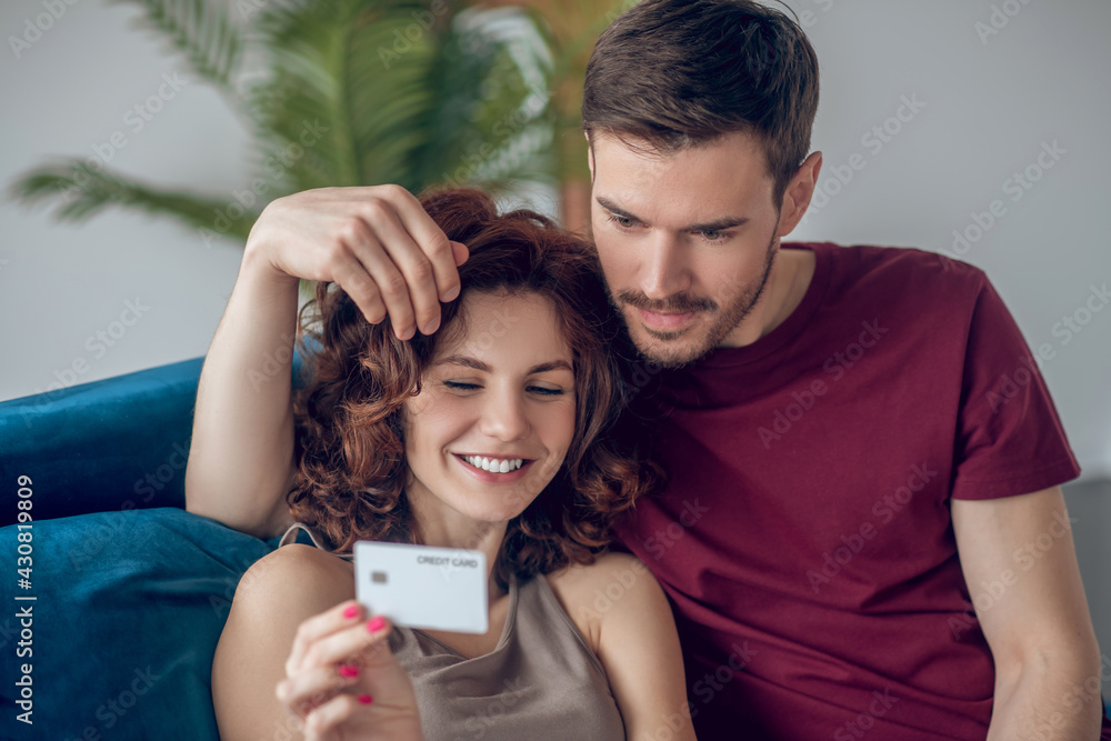 A young couple discussing what to buy online A young couple discussing what to buy online