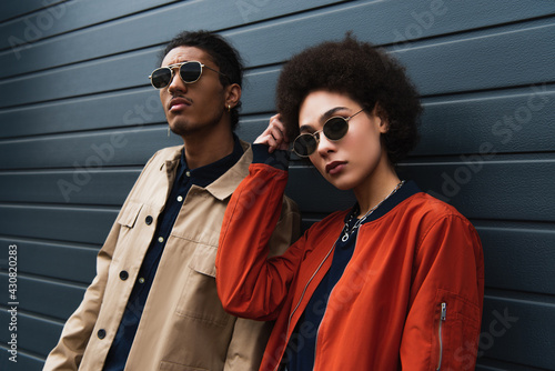young african american man posing with stylish woman in sunglasses outside