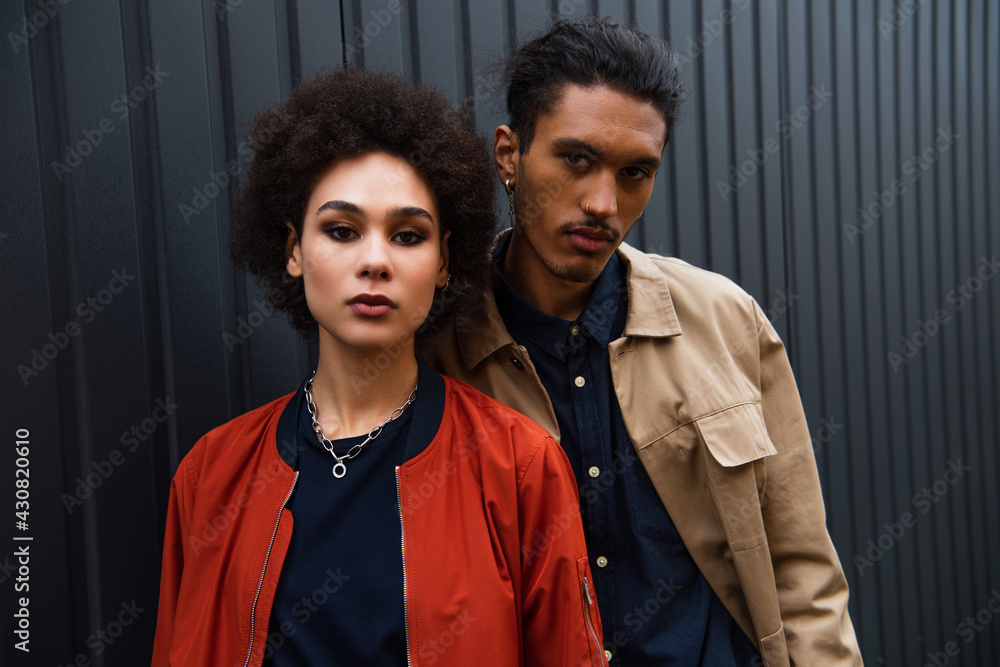 african american couple in trendy jackets posing outside african american couple in trendy jackets posing outside