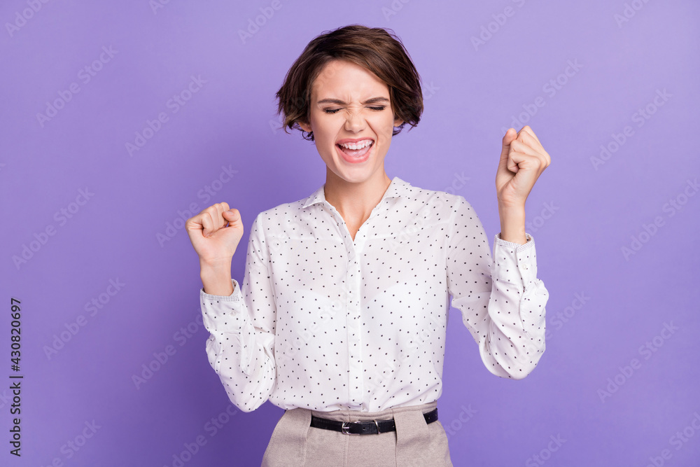 Portrait of delighted lady closed eyes open mouth fists up celebrate isolated on purple color background Portrait of delighted lady closed eyes open mouth fists up celebrate isolated on purple color background