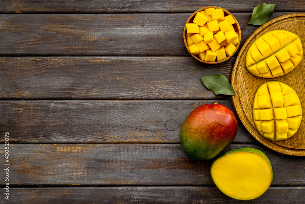 Tropical mango slices and cubes in wooden bowl Tropical mango slices and cubes in wooden bowl