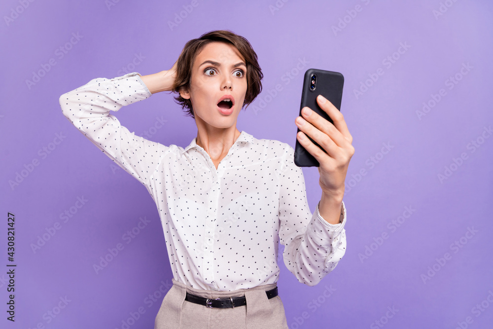 Portrait of impressed person arm on head open mouth staring phone isolated on purple color background Portrait of impressed person arm on head open mouth staring phone isolated on purple color background