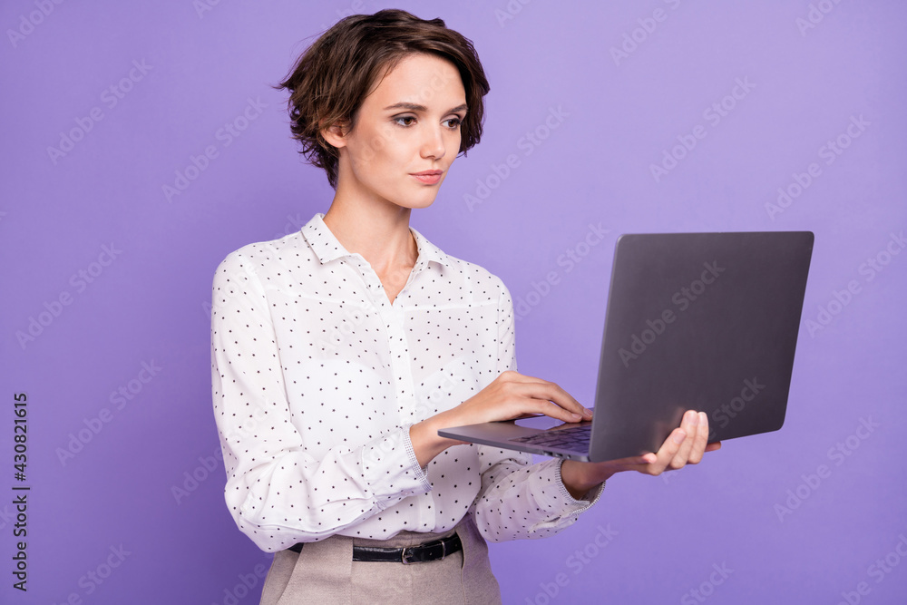 Portrait of nice brunette short hair optimistic lady hold laptop wear white shirt isolated on lilac color background Portrait of nice brunette short hair optimistic lady hold laptop wear white shirt isolated on lilac color background