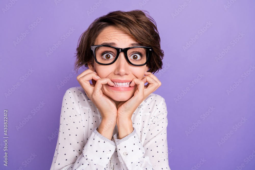 Photo of nice brunette short hair scared lady bite fingers wear shirt isolated on lilac color background Photo of nice brunette short hair scared lady bite fingers wear shirt isolated on lilac color background
