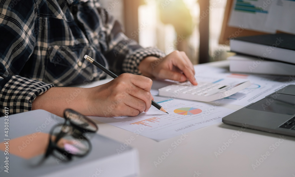 Bookkeeper or financial inspector using a calculator to calculate report profit, analyzer graph balance, tax. Business accountant concept Bookkeeper or financial inspector using a calculator to calculate report profit, analyzer graph balance, tax. Business accountant concept