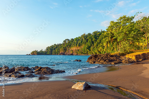 Tropical rainforest beach at sunset by Pacific Ocean, Corcovado national park, Costa Rica. photo