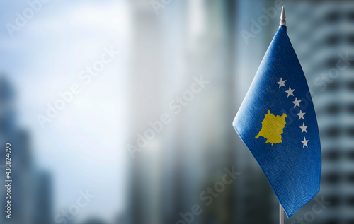 A small flag of Kosovo on the background of a blurred background