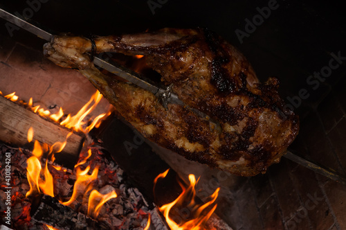 the back of a lamb on a spit with a glass of brandy photo