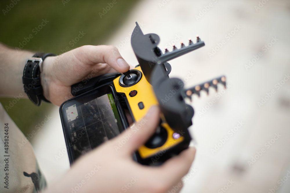 The man controls the drone from the remote control The man controls the drone from the remote control
