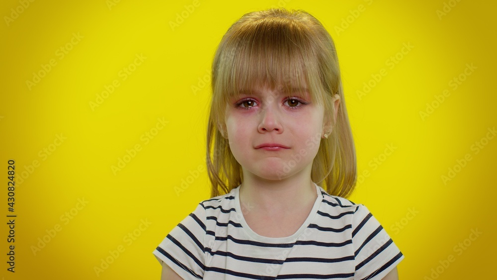 Disappointed upset little blonde teen kid child girl with tears on eyes cries from despair, being sad because of unfair things. Isolated on yellow studio background. Young children lifestyle emotions Disappointed upset little blonde teen kid child girl with tears on eyes cries from despair, being sad because of unfair things. Isolated on yellow studio background. Young children lifestyle emotions