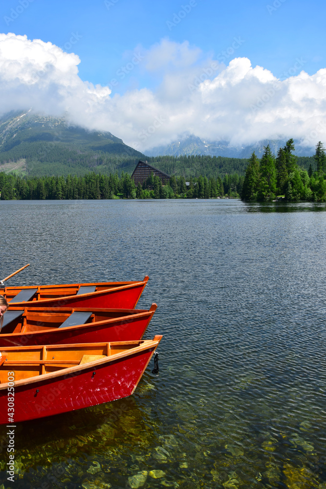 Lake Strbské pleso and a hotel in the High Tatras, Slovakia. Orange boats in front.