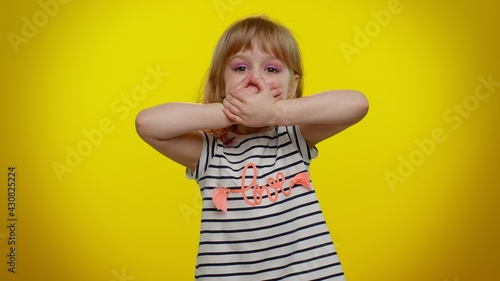 I will not say anyone. Frightened little blonde teen kid child girl closing her mouth with hand, looking intimidated scared at camera, gestures no, refusing to tell terrible secret, unbelievable truth