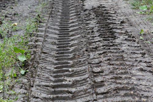 Tracks of tread of tires of a tractor and an SUV on a forest dirt road