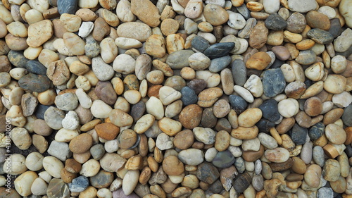 Pebble stone or river stone on floor for garden decoration. Landscape design , garden idea , simplicity stone background concept. Flat lay texture in daylight