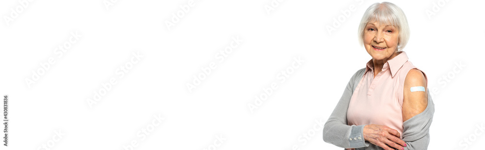 Senior woman with adhesive patch on arm smiling at camera isolated on white, banner Senior woman with adhesive patch on arm smiling at camera isolated on white, banner