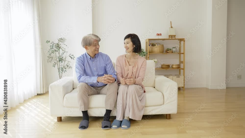 リビングで話をする中高年夫婦 リビングで話をする中高年夫婦