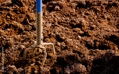 Handheld garden claw cultivator and soil.