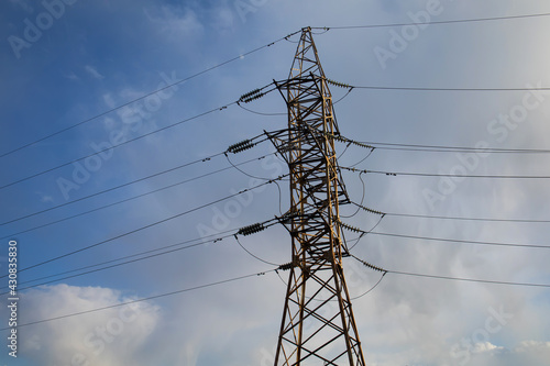 Low Angle Shot Of An Electric Tower Under Blue Cloudy Sky photo