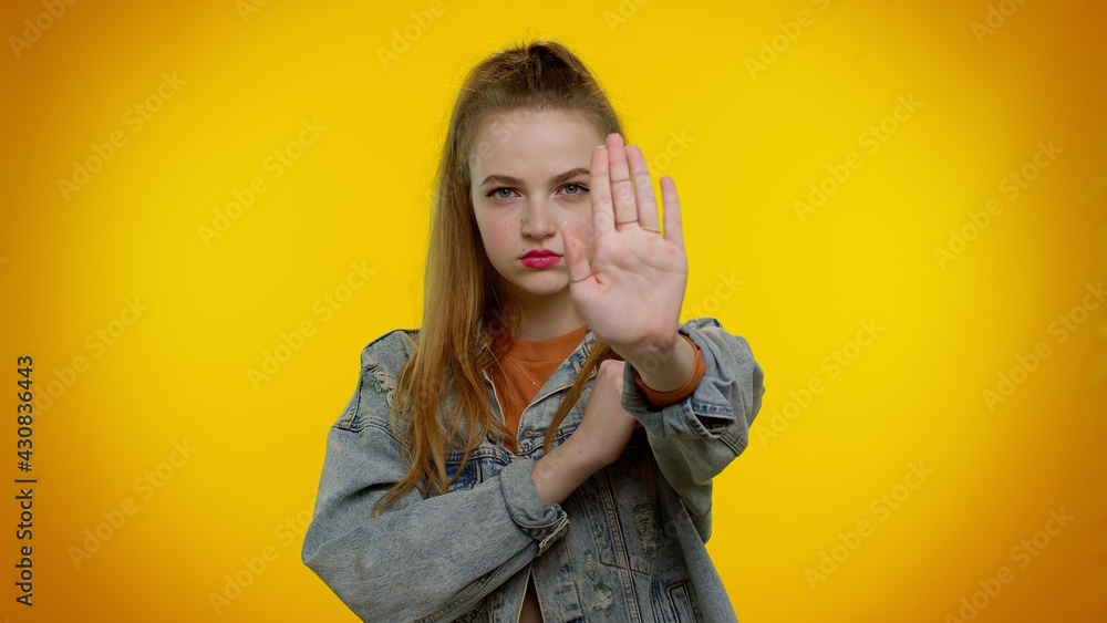 No stop. Stylish adult girl say no hold palm folded crossed hands in stop danger gesture, warning of finish, prohibited access, declining communication, body language. Young woman on yellow background No stop. Stylish adult girl say no hold palm folded crossed hands in stop danger gesture, warning of finish, prohibited access, declining communication, body language. Young woman on yellow background