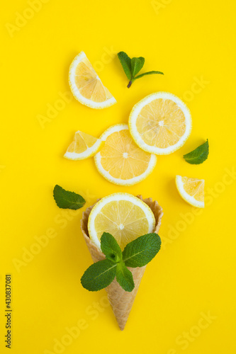 Ice cream cone with chopped  lemon and mint on  the yellow  background. Close-up.