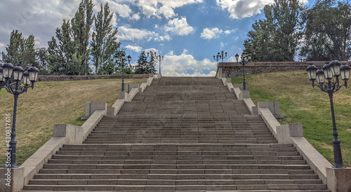 Stairway to Heaven .Bottom view of a wide stone pedestrian staircase in the city. Thick white-gray clouds are at the top. Growth and recovery concept. Empty staircase. © AntKus