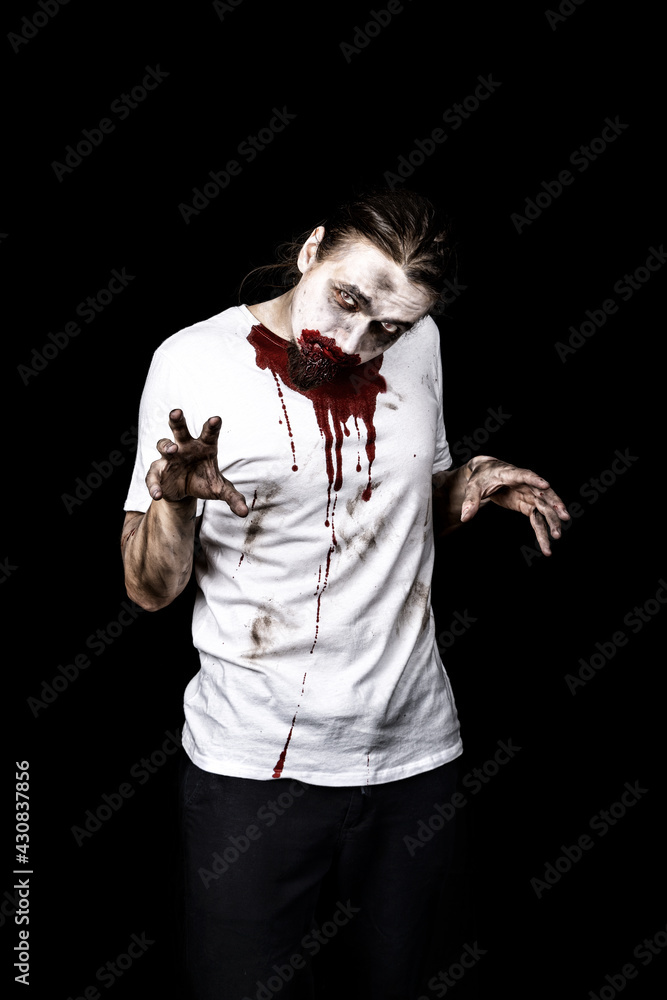 Zombie with bloody mouth, long hair and beard. Man with a dirty, bloody white shirt isolated on black. Zombie with bloody mouth, long hair and beard. Man with a dirty, bloody white shirt isolated on black.