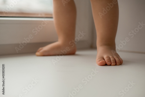 child's feet on the windowsill of the house near the window close-up © КРИСТИНА Игумнова